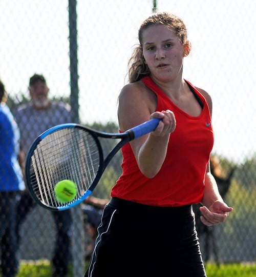 girls tennis student hitting tennis ball